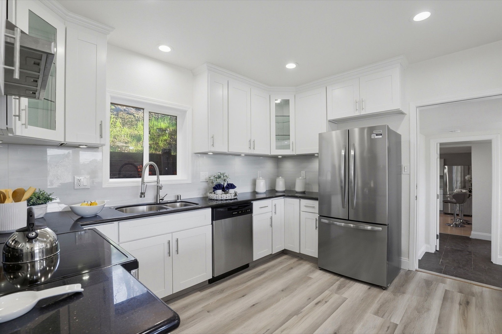 Remodeled kitchen with white cabinetry and stone counters
